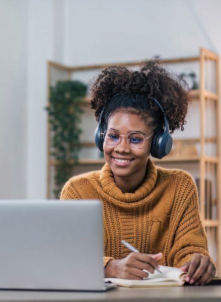 Estudiante con auriculares tomando clase online en portátil